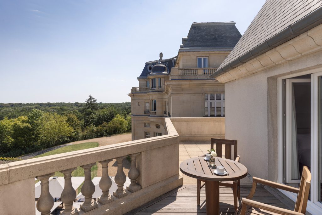 Suite spacieuse et lumineuse avec coin salon et grandes fenêtres ouvertes sur la nature.
